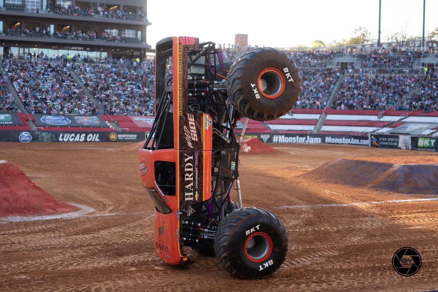 Hardy monster truck performs a wheelie stunt at Protective Stadium dirt arena before packed crowd.