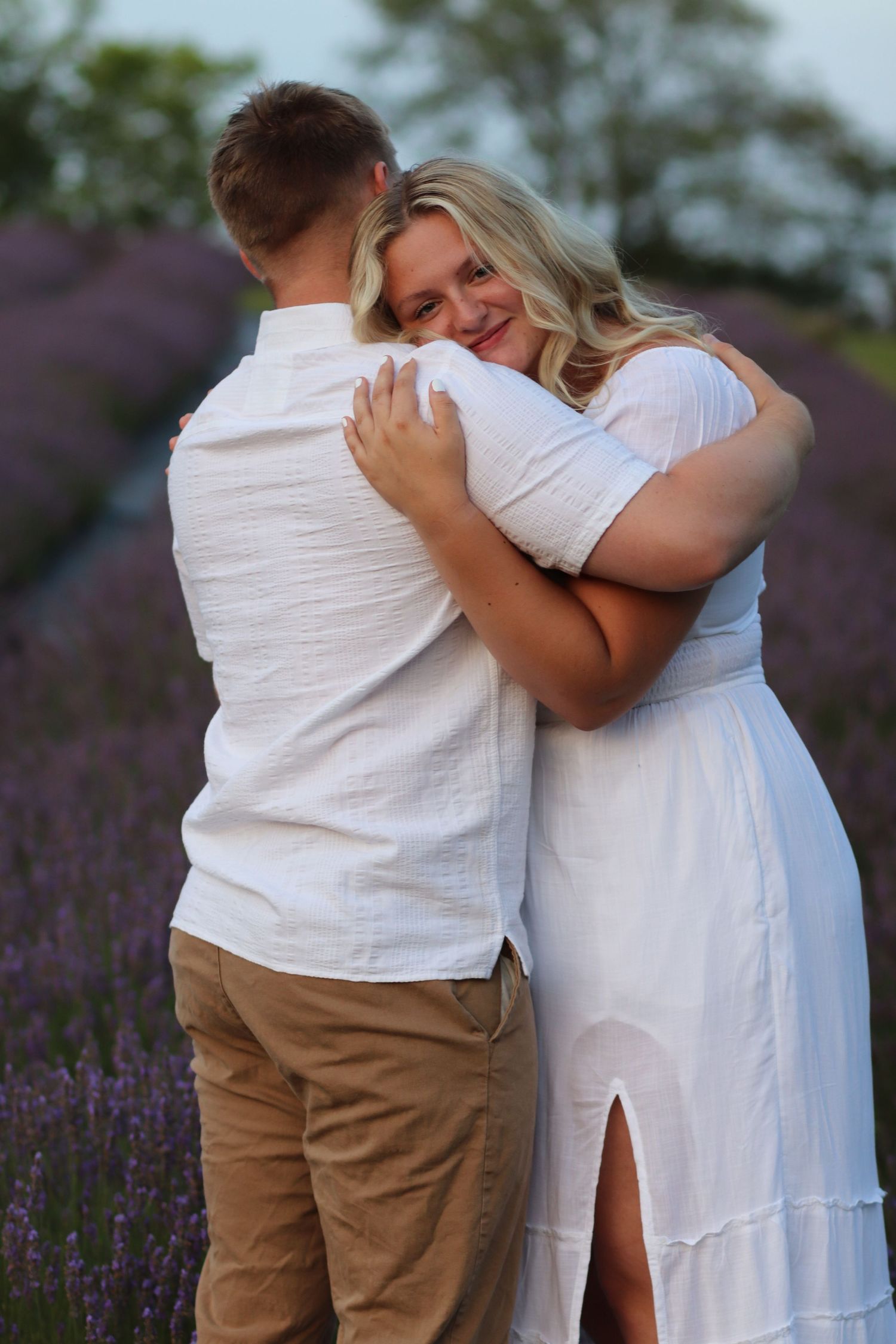 Couple embracing in a lavender field at dusk.