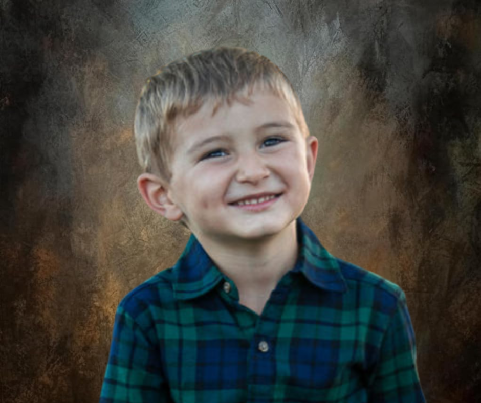 Smiling young boy with blonde hair wearing a green plaid shirt, posed against a warm brown studio background.