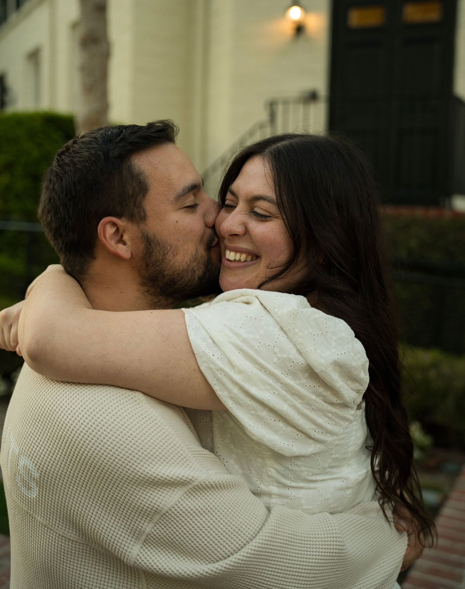 A couple hugging with the husband holding his wife up and she is smiling