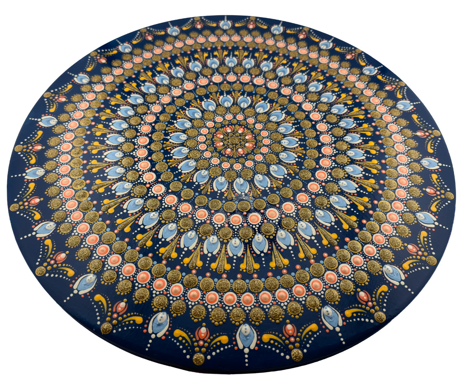 Intricate circular mandala artwork with concentric patterns in blue, gold, pink, and white on a dark navy background.