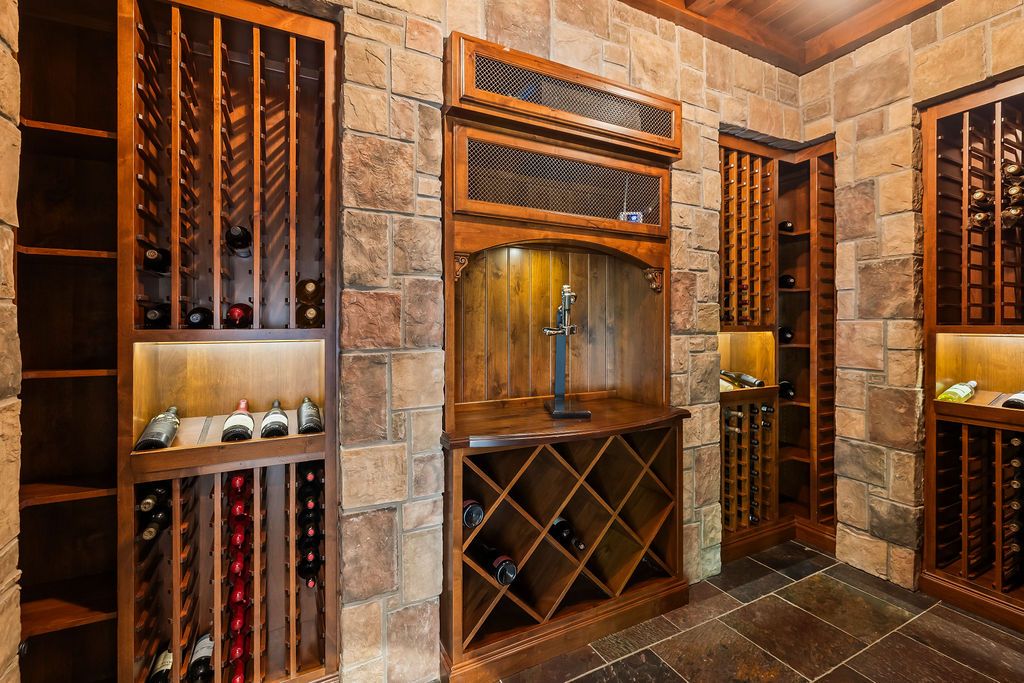 Elegant wine cellar with wooden racks, diamond storage, and stone walls showcasing an extensive wine collection.