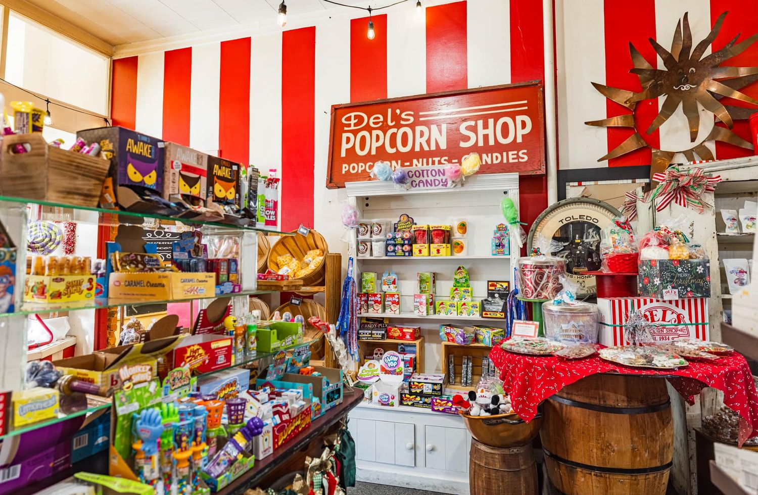 Interior of Del's Popcorn Shop with red and white striped walls, candy displays, and vintage decor.