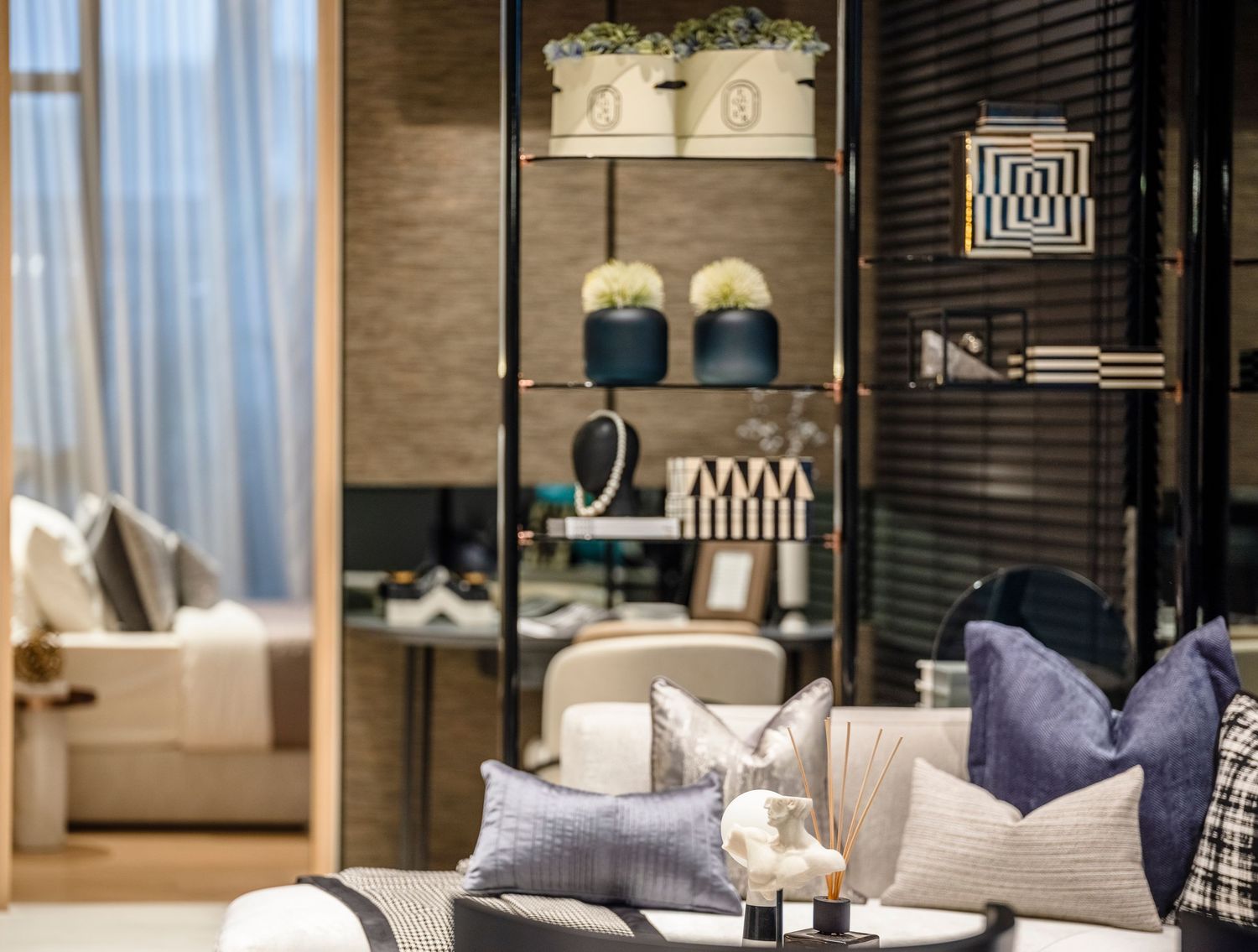 Elegant luxury living room display with navy cushions, decorative shelving, and sophisticated home accessories.