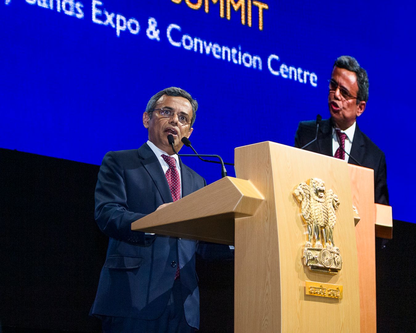 Two men speaking at a podium at the India Singapore Summit at Marina Sands Expo & Convention Centre.