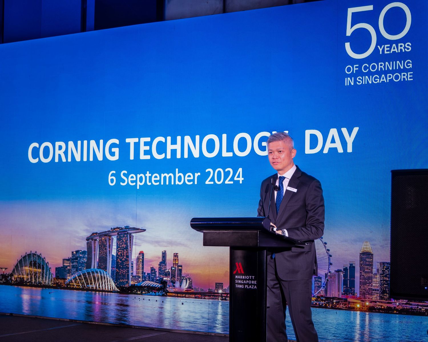 Executive speaks at Corning Technology Day podium celebrating 50 years in Singapore, September 2024.