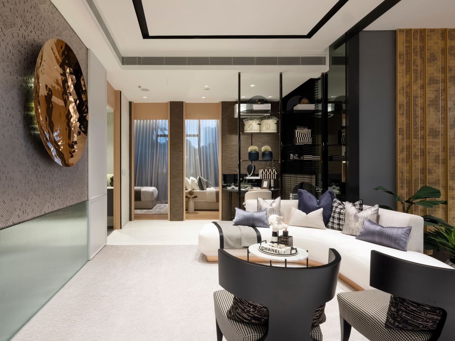 Luxurious modern living room with white sofa, dark chairs, gold wall art, and elegant decor.
