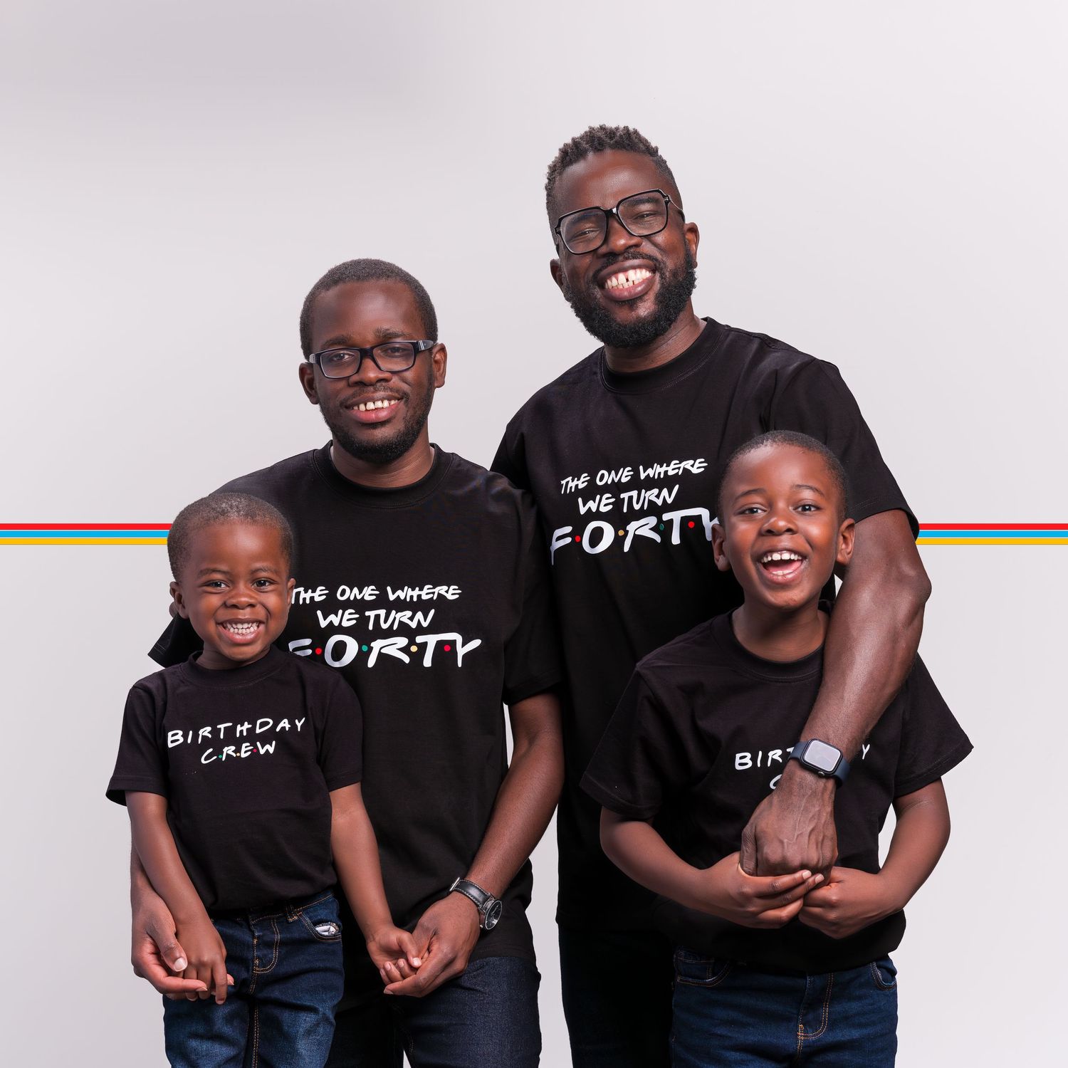 Family of four wearing matching black birthday crew T-shirts, smiling together in a celebratory photo.