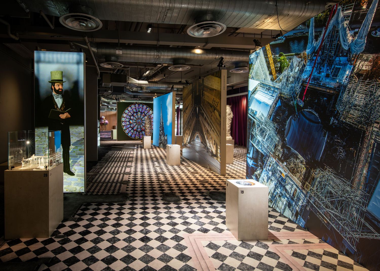 Interactive museum exhibit with checkered floor, illuminated displays, and colorful artistic installations in a modern gallery space.