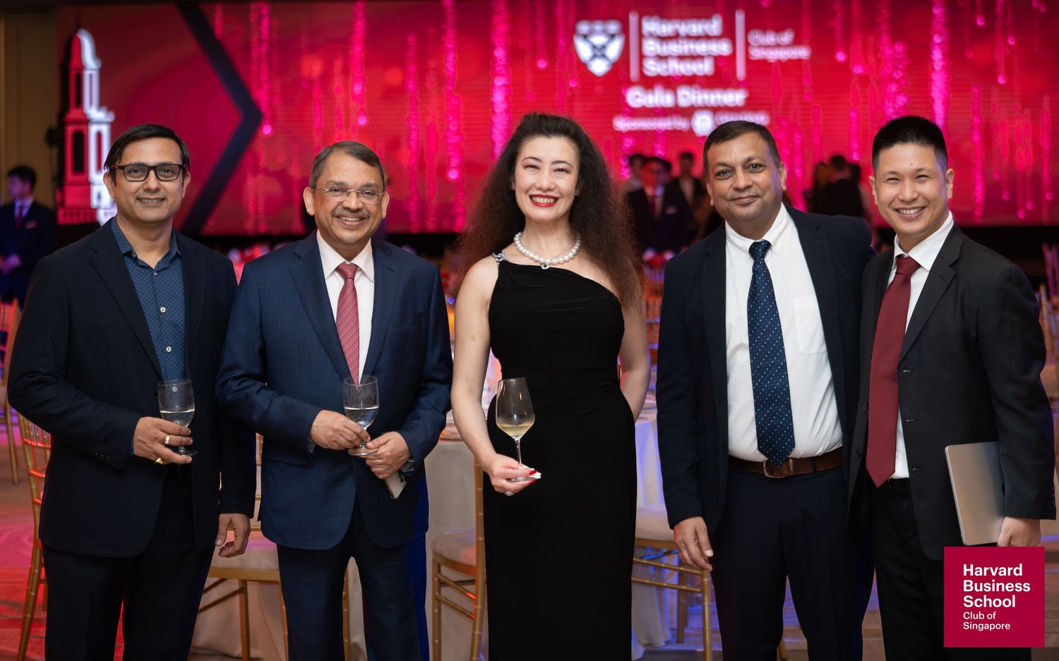 Five professionals posing together at Harvard Business School Gala Dinner event in formal attire.