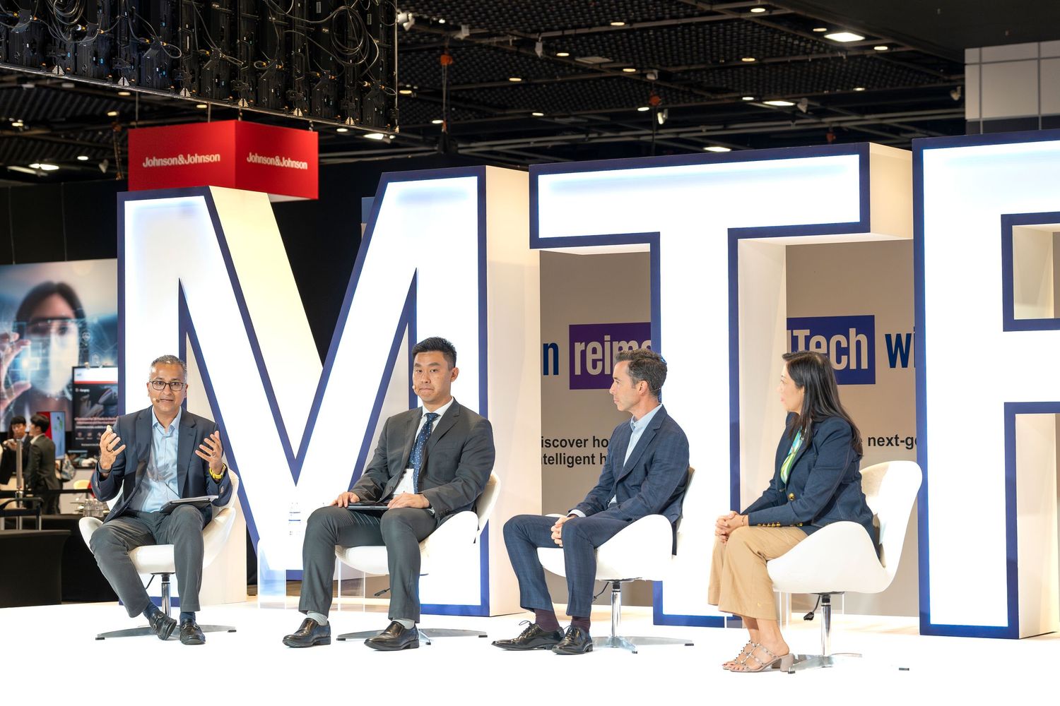 Four panelists seated on stage at an MTR reimagine TechWeek conference discussion event.
