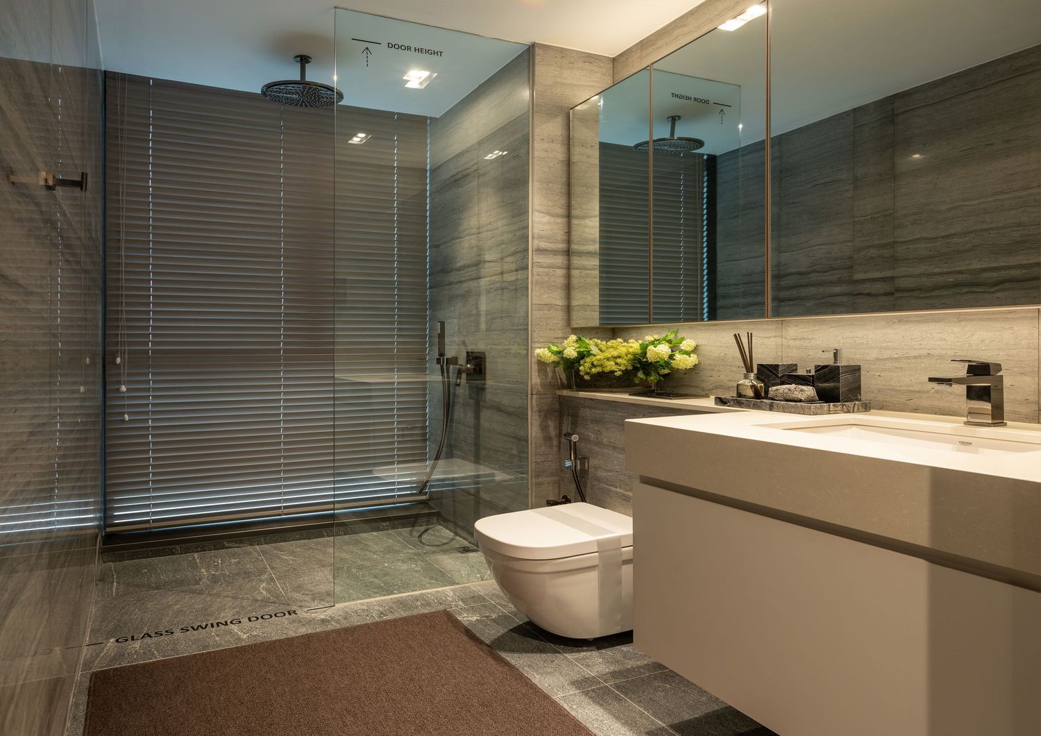 Modern bathroom with glass shower enclosure, wall-mounted toilet, floating vanity, large mirror, and elegant gray marble tiles.