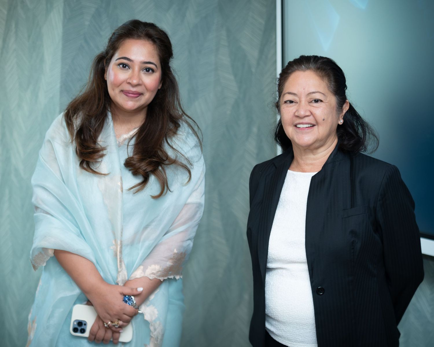 Two women smiling and posing together at a professional conference event.