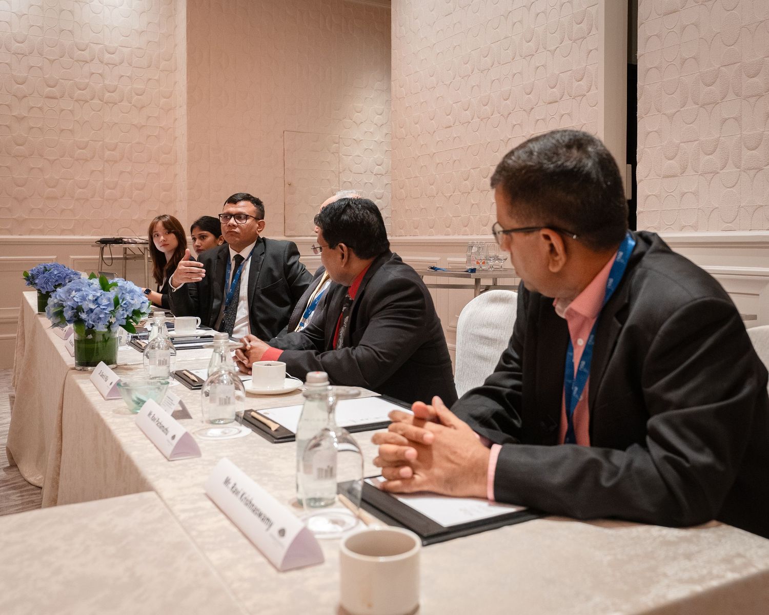 Group of professionals seated at a conference table during a formal business meeting.