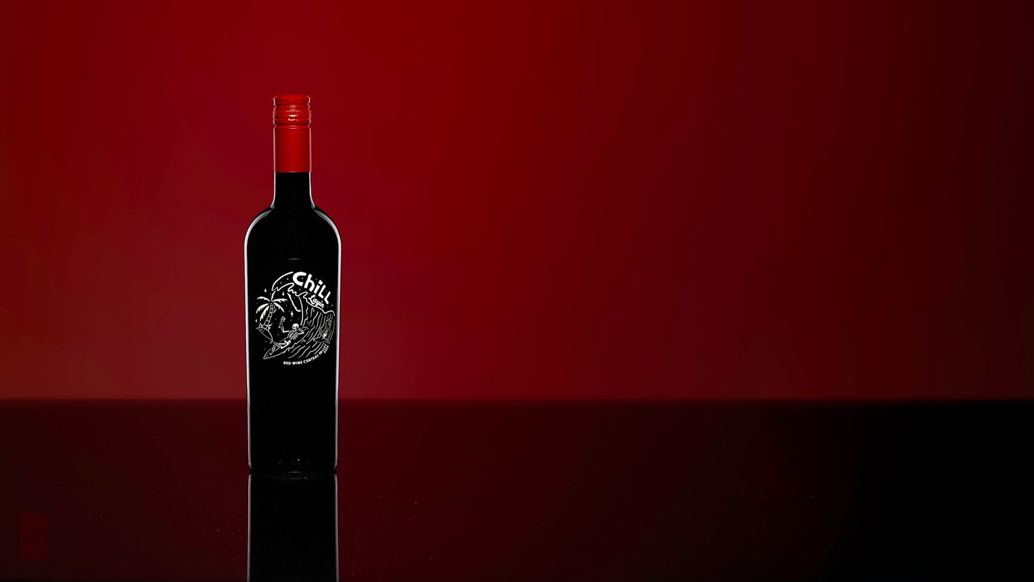 Dark wine bottle with ornate label displayed against a dramatic deep red background with glossy reflection.