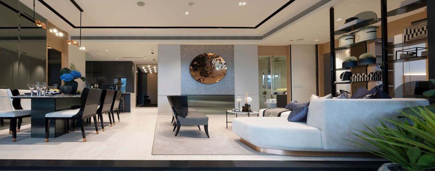 Elegant open-plan luxury apartment featuring white sofa, dark furniture, and modern interior design.