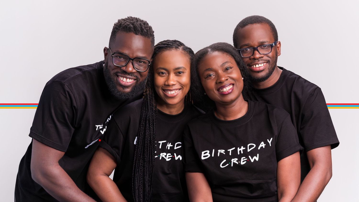 Four friends smiling in matching black Birthday Crew t-shirts posing together for a group photo.