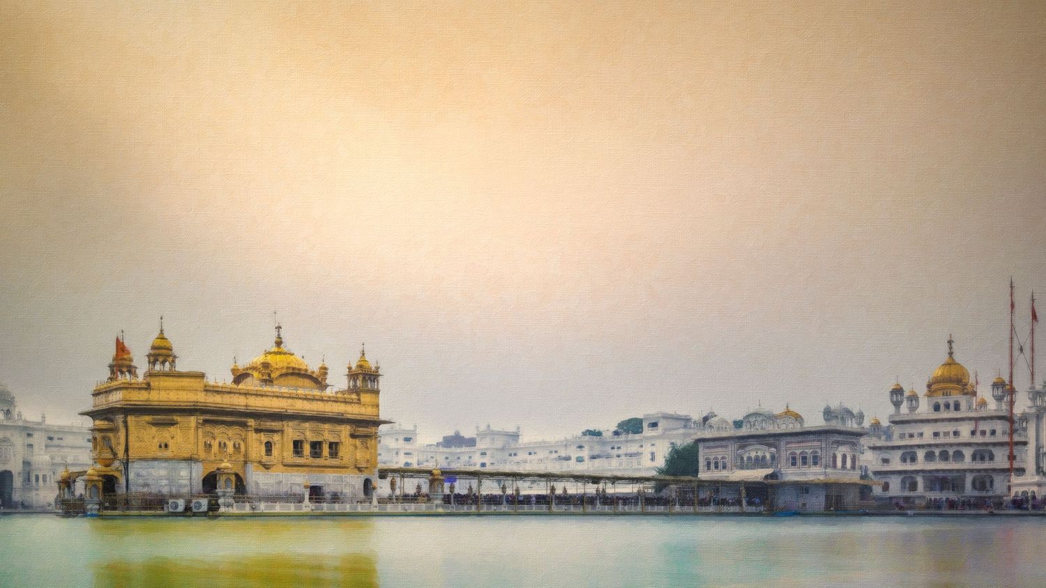 Golden Temple of Amritsar gleaming in golden hues reflected on sacred waters under a misty sky in Punjab, India.