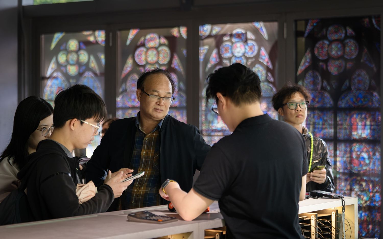 Group of people gathered around table discussing art in museum gallery.