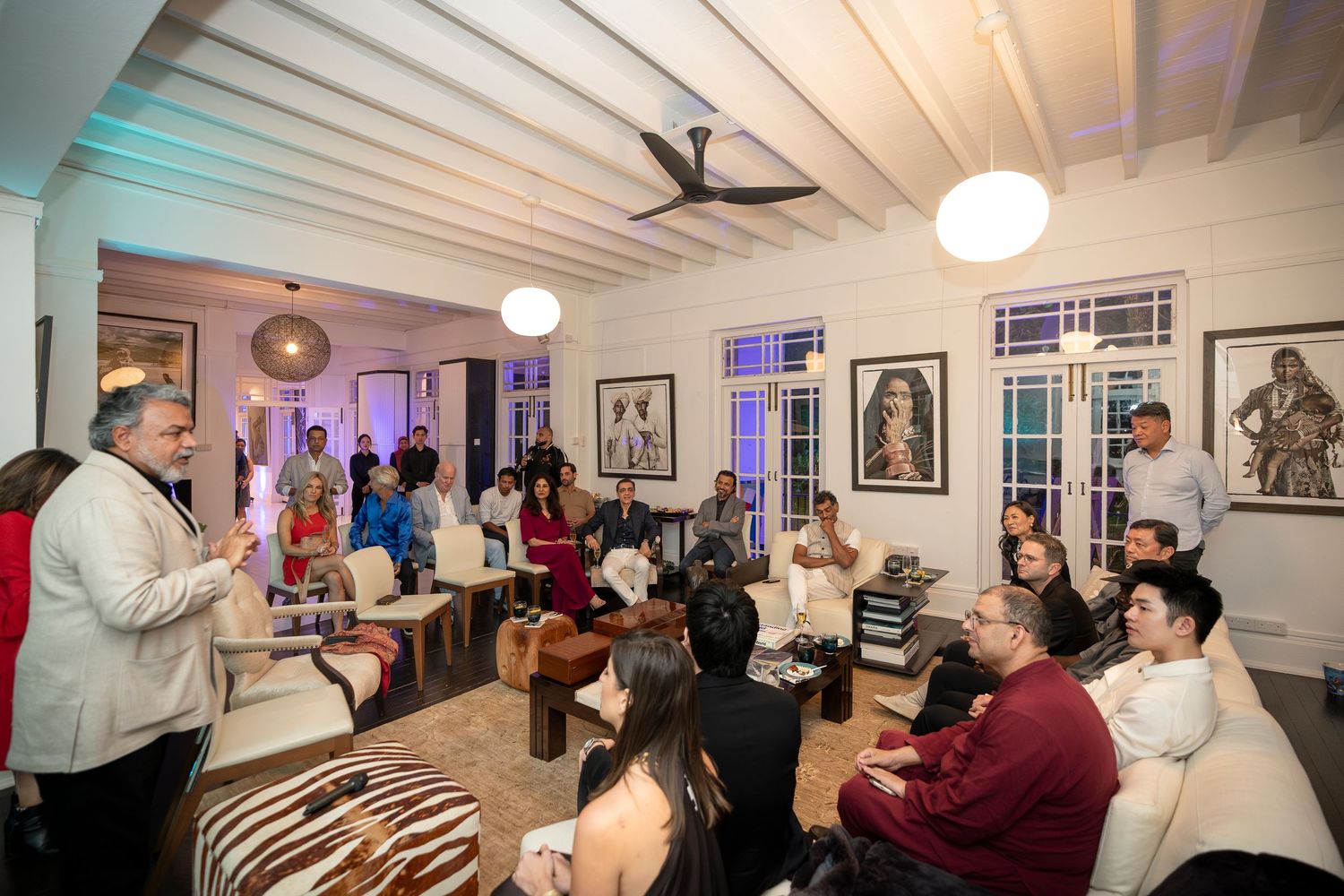 People gathered in an elegant living room for an intimate indoor social event or presentation.
