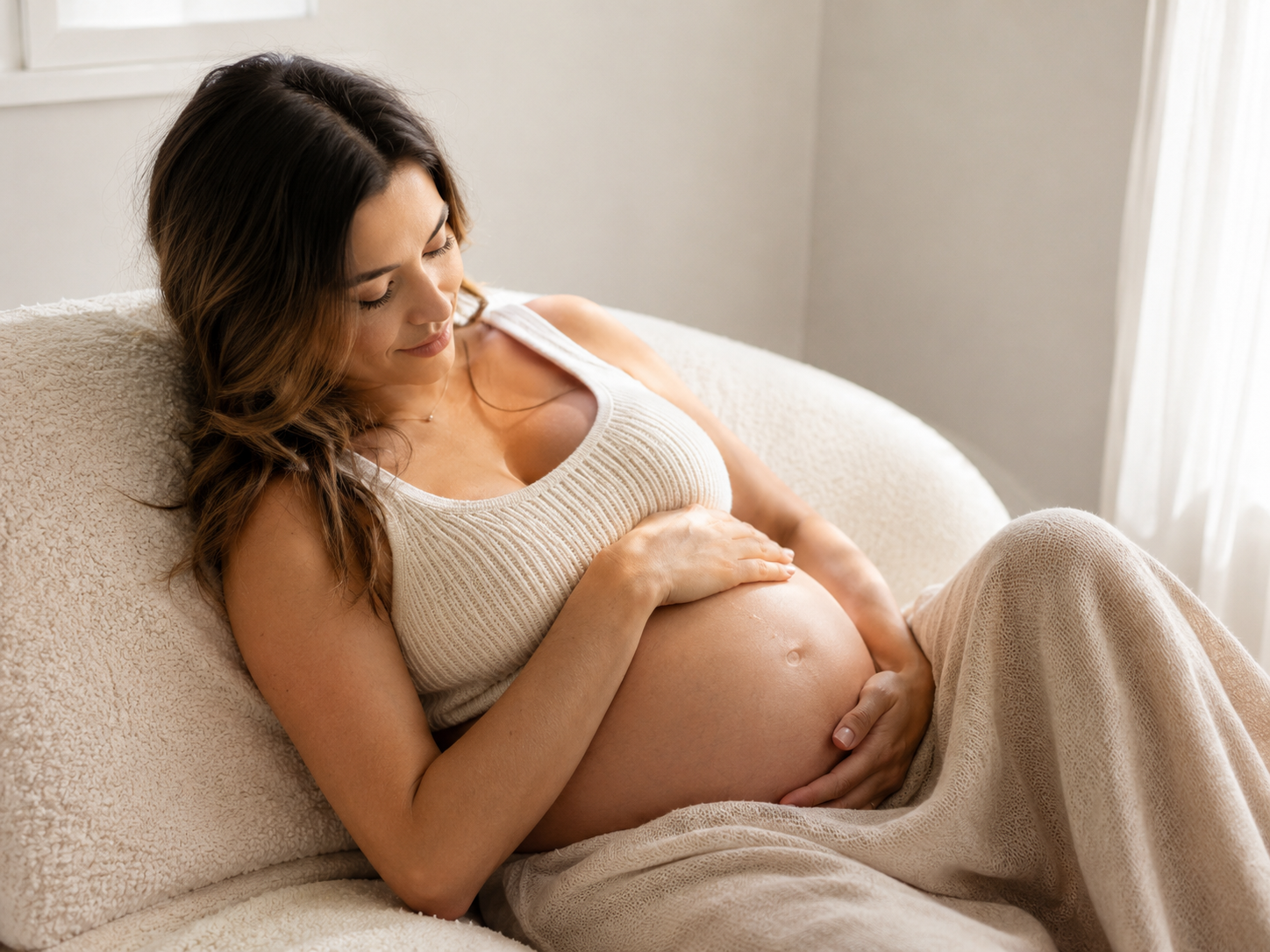 Séance photo grossesse en studio à Vevey, future maman allongée dans une lumière douce