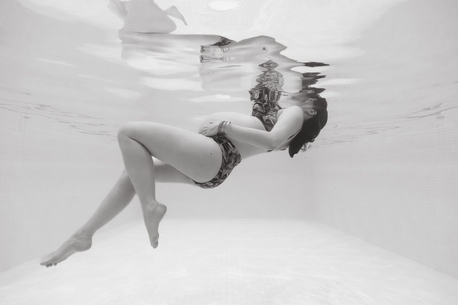 Séance grossesse aquatique à Vevey, future maman sous l’eau dans un bassin privatisé
