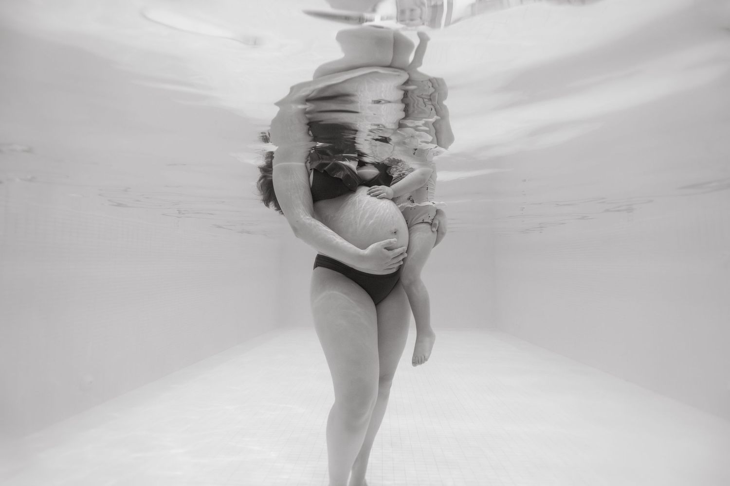 Séance photo aquatique maman enfant à Vevey, future maman avec son enfant dans l’eau