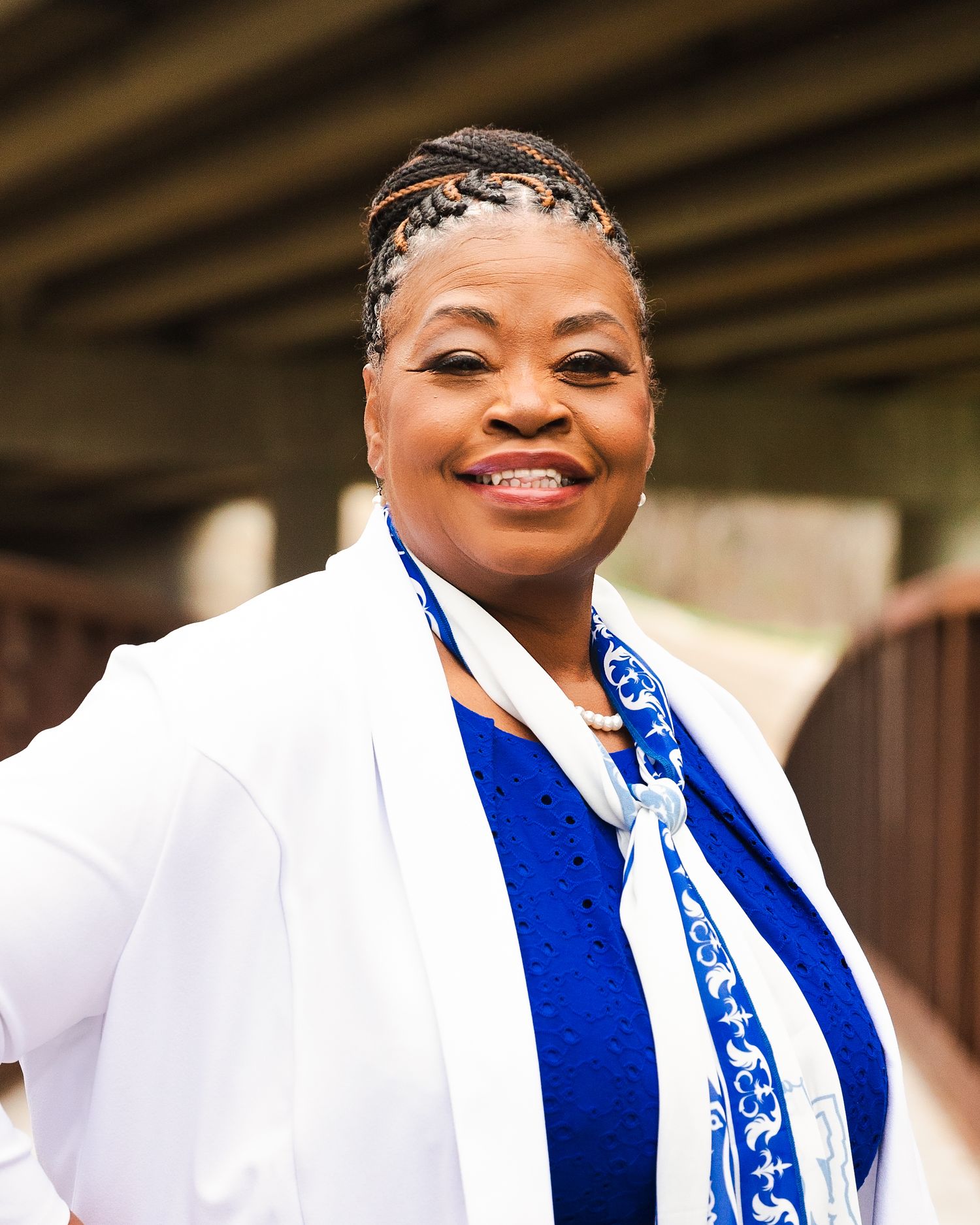 Joyful portraits wearing white and royal blue graduation regalia with decorative stole.