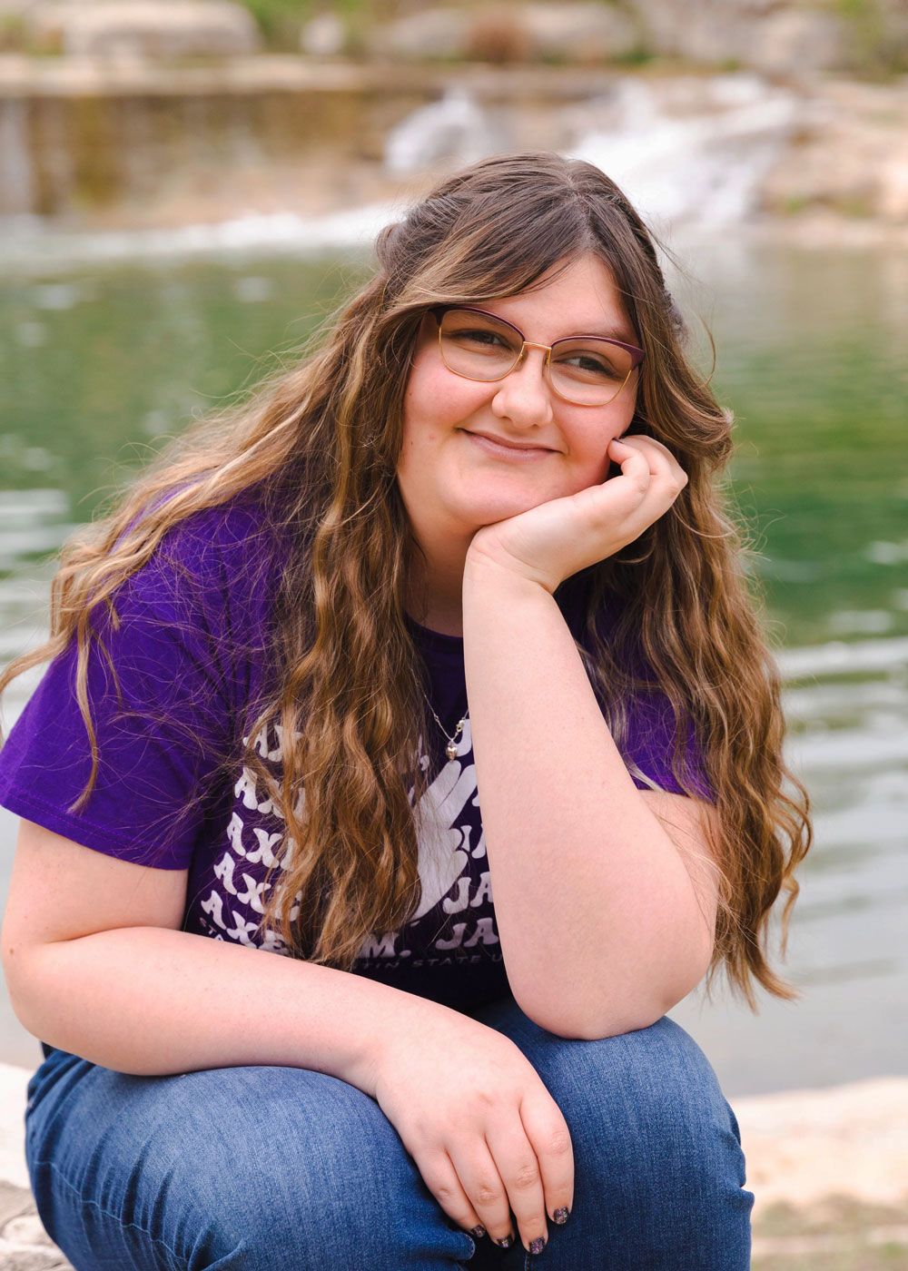 Casual portraits by a lake featuring someone in purple shirt and jeans.