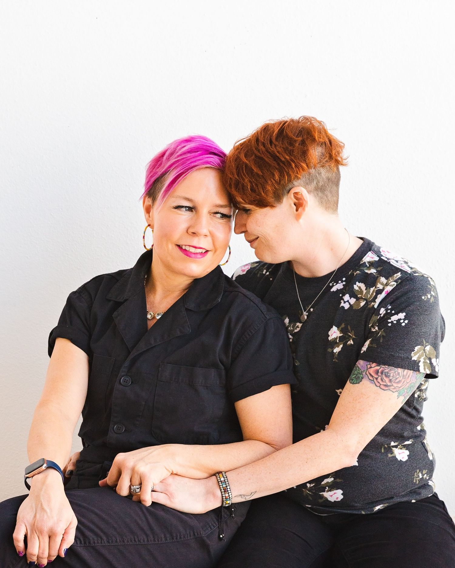 Two people in black outfits share intimate moment during photo session.