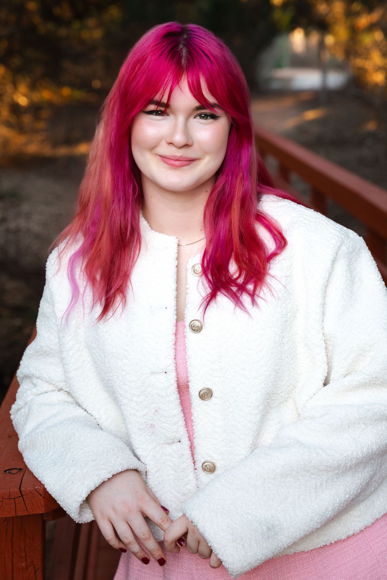 Portrait series showing person with vibrant pink hair wearing white fuzzy jacket outdoors.