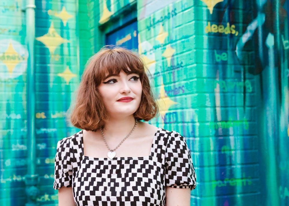 Urban portrait series against a geometric teal and yellow wall mural.