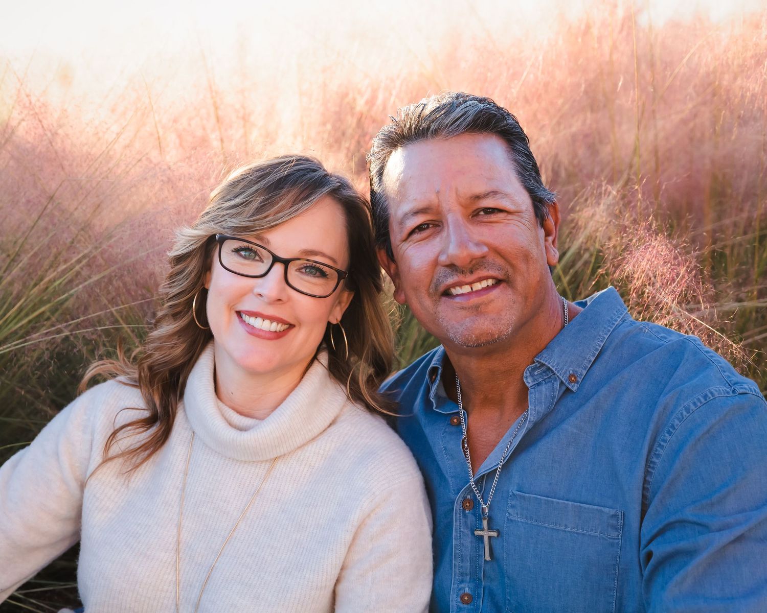 Couple in casual winter wear poses together during golden hour photoshoot.