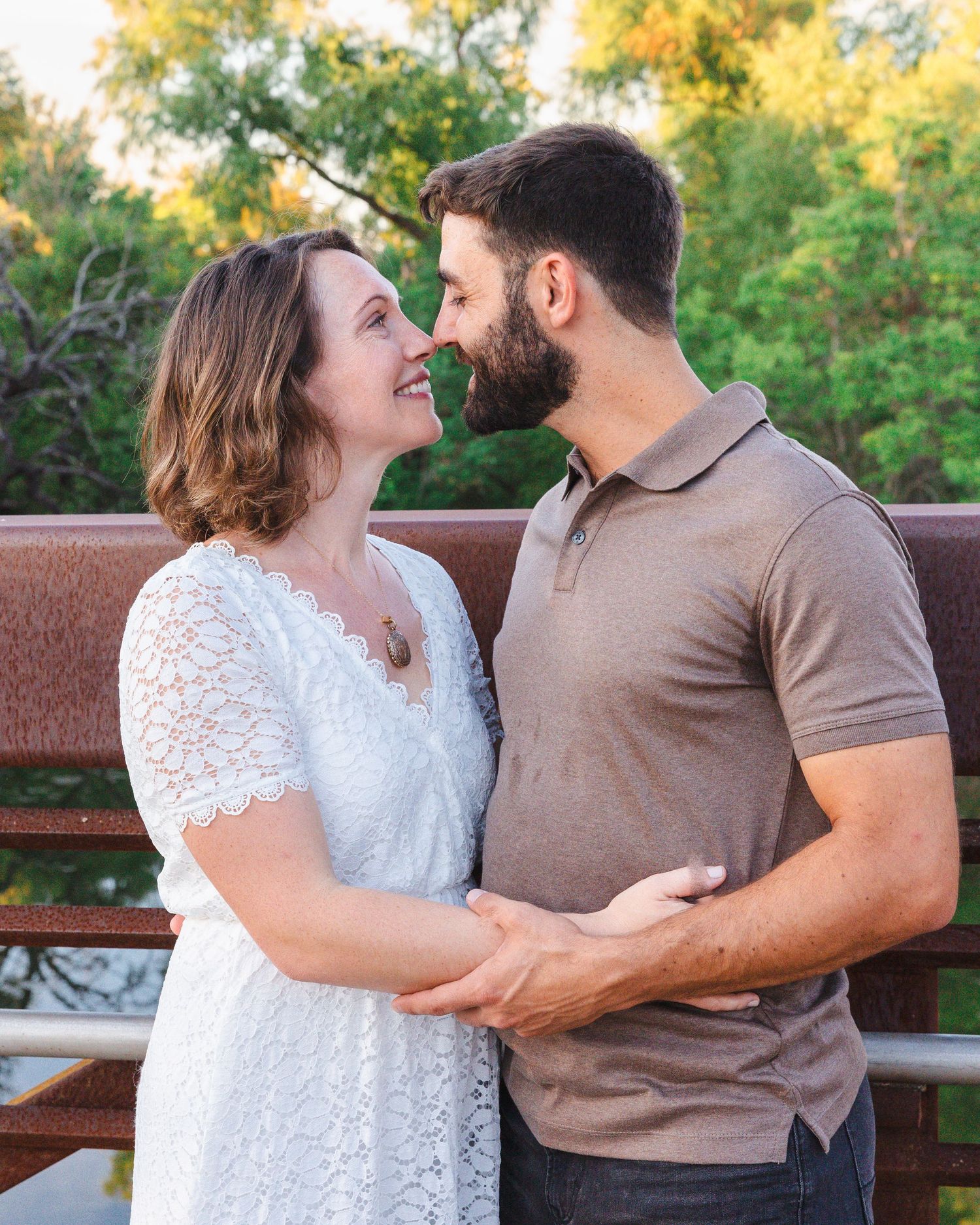 Couple in coordinated outfits sharing intimate moments on a park bench.