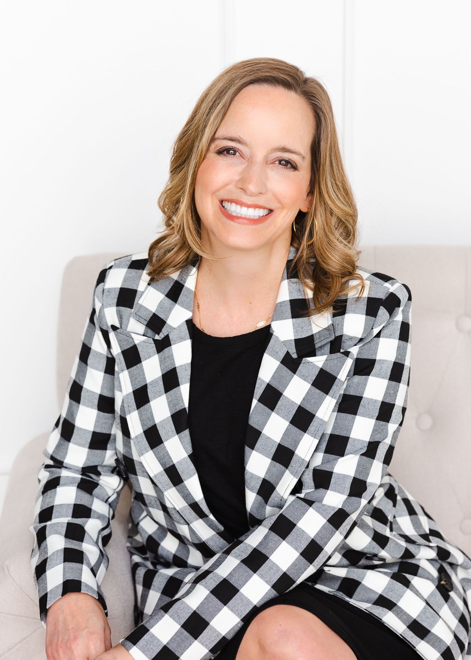Series of professional portraits featuring black and white checkered blazer against light backdrop.