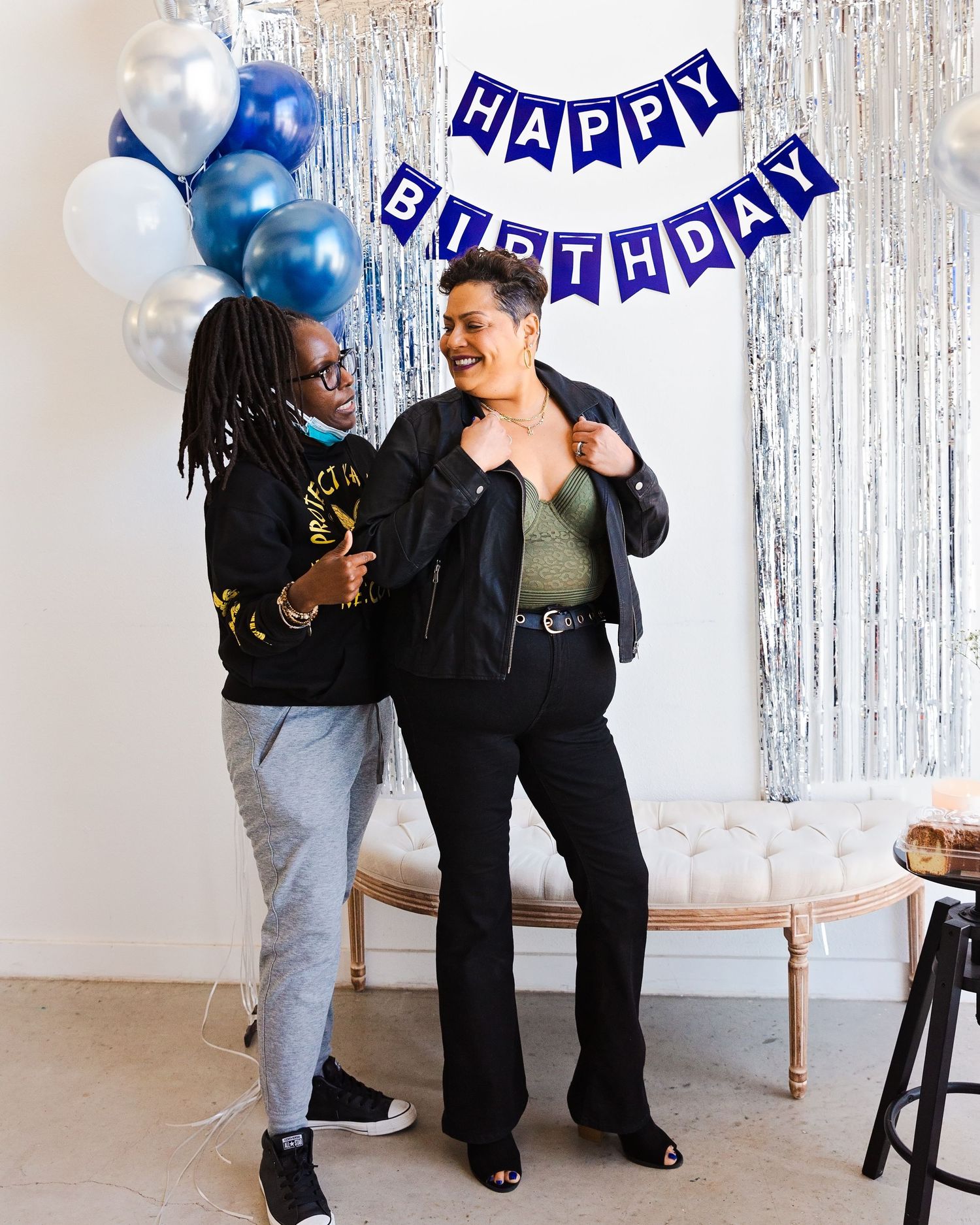 Birthday party decorations with silver tinsel backdrop and blue balloons for a festive celebration.