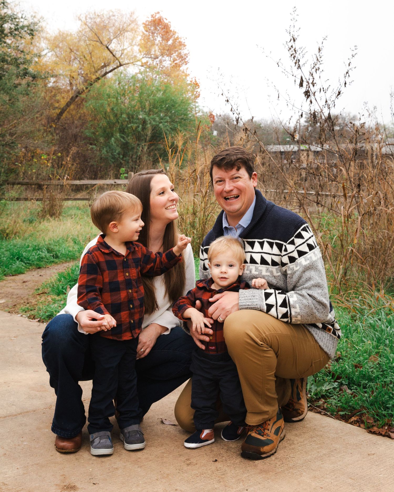 Outdoor family portrait in autumn with parents and two small children on path. Austin, TX