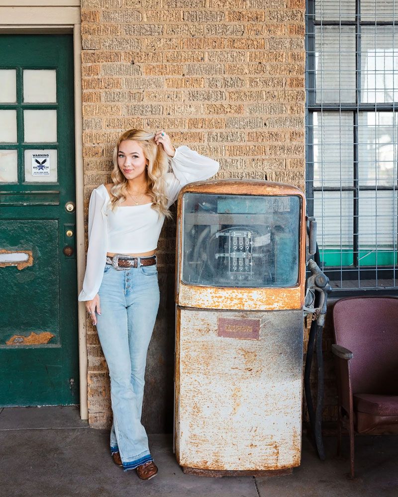 A vintage industrial setting with brick walls and rustic metal equipment serves as a photo backdrop.