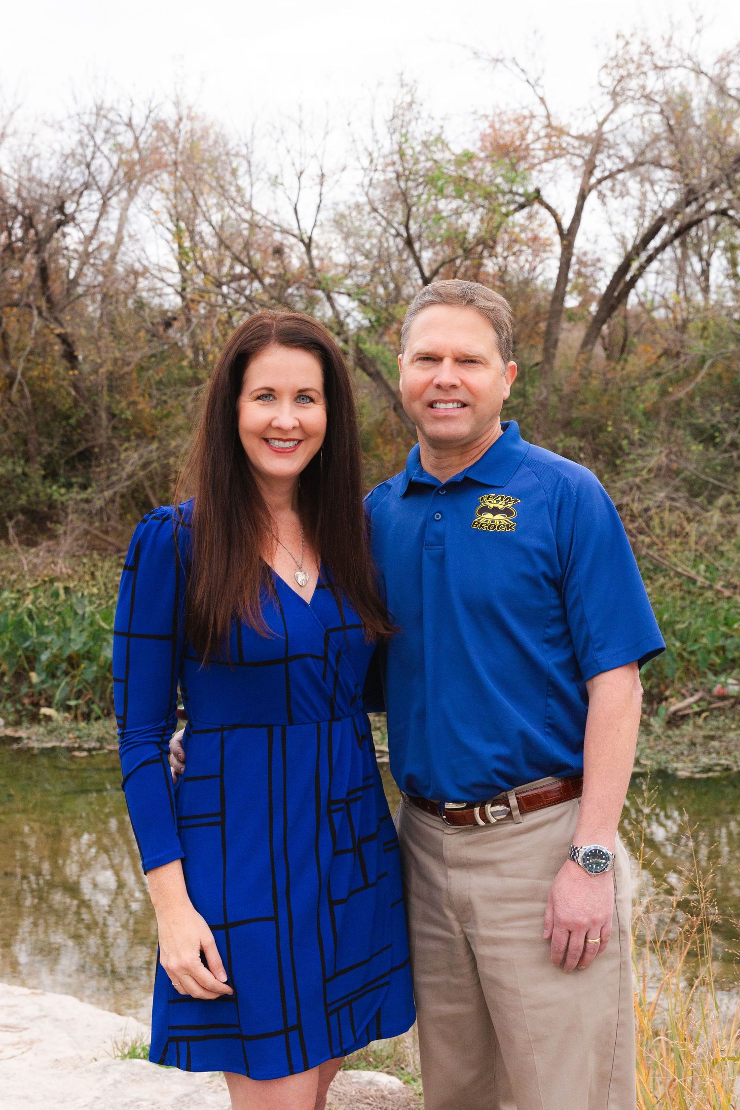 Couple in coordinating blue outfits posing together outdoors.