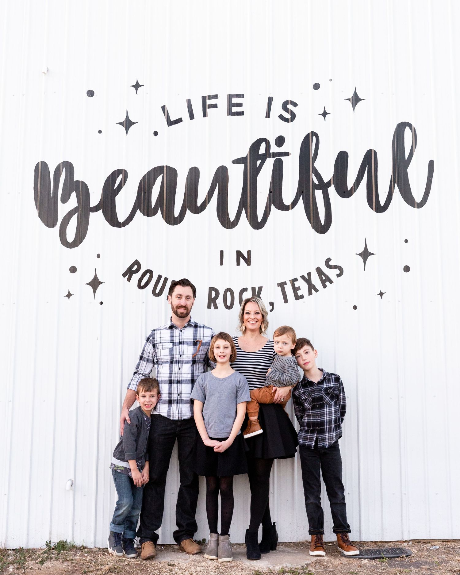 Family group photos against a white wall with decorative text art.