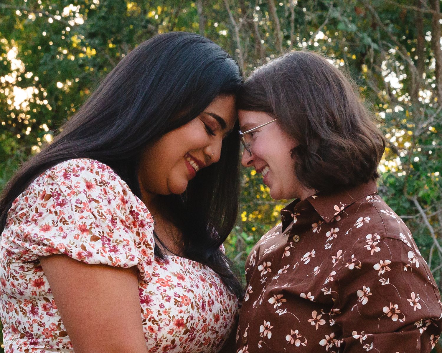 Couple in floral and brown outfits sharing tender moments in a garden setting.