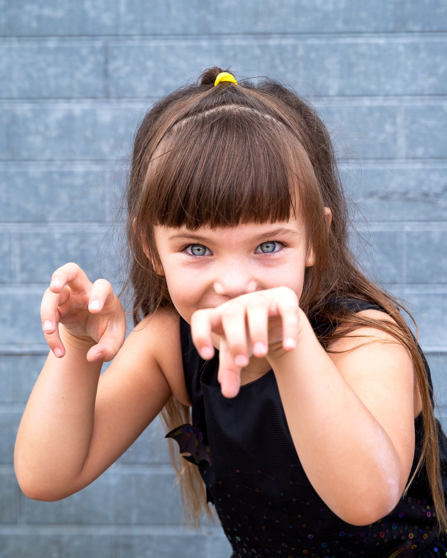 Playful portrait series against blue wall with animated hand gestures. Fun child photography Round Rock, TX