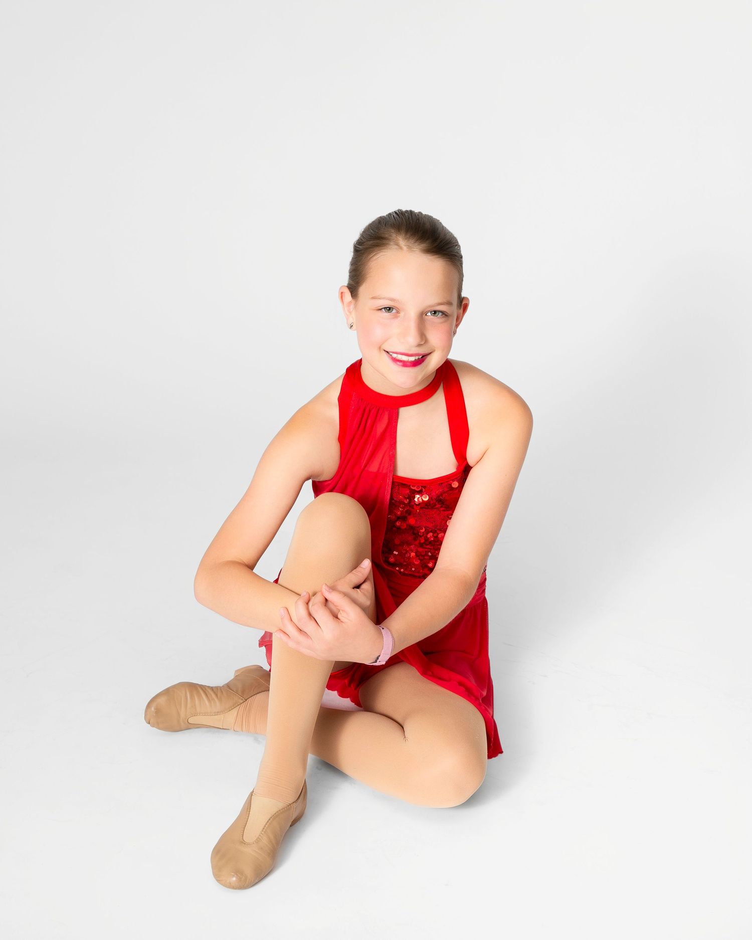 Dancer in red leotard strikes dynamic poses during studio photo session.