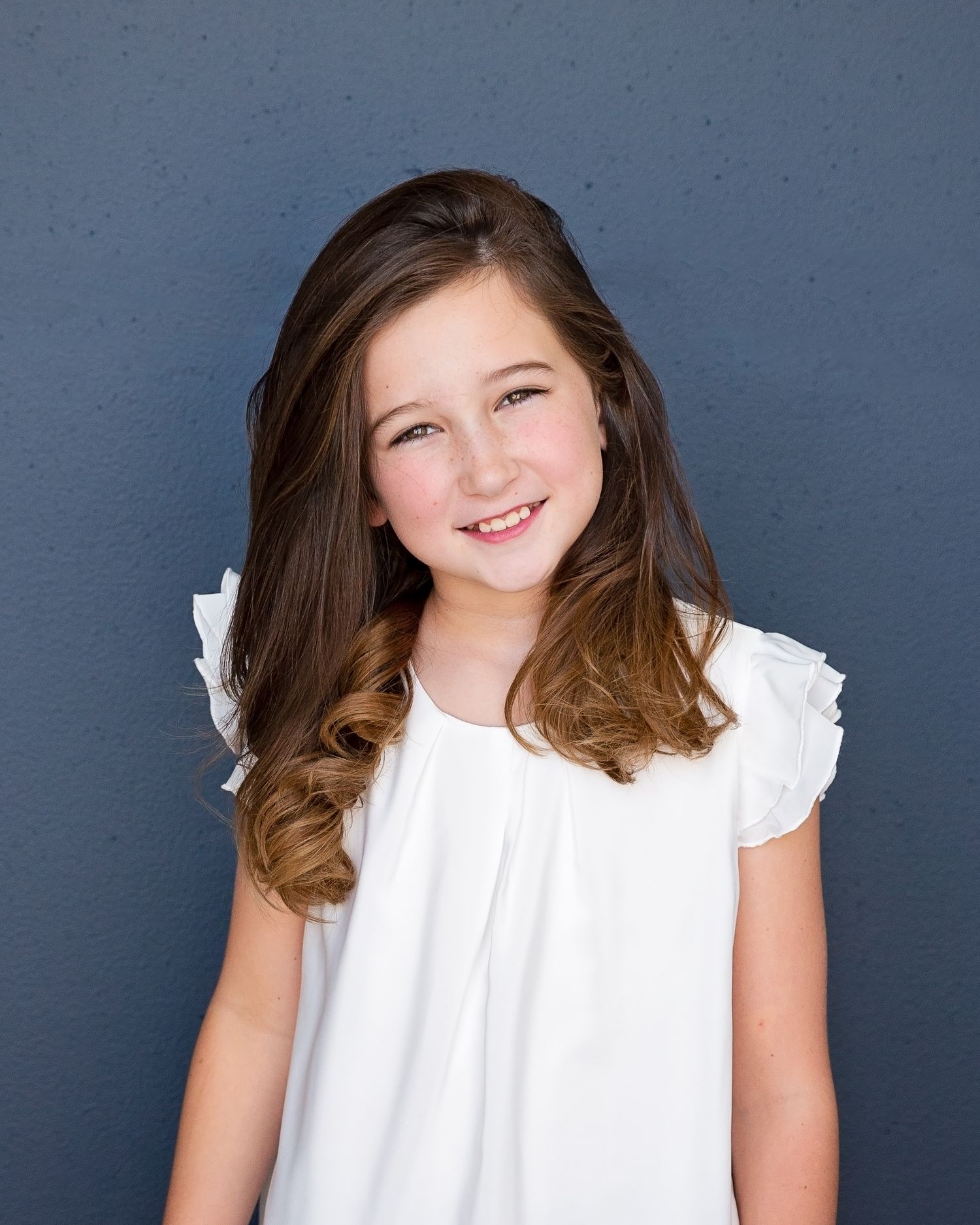 Portrait series showing a white ruffled dress against a dark blue background.