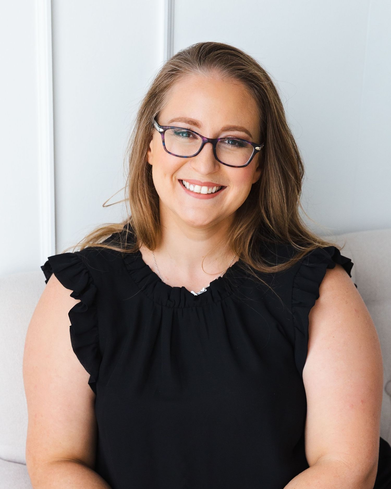 Professional headshots showing person in black sleeveless top and glasses against white background.