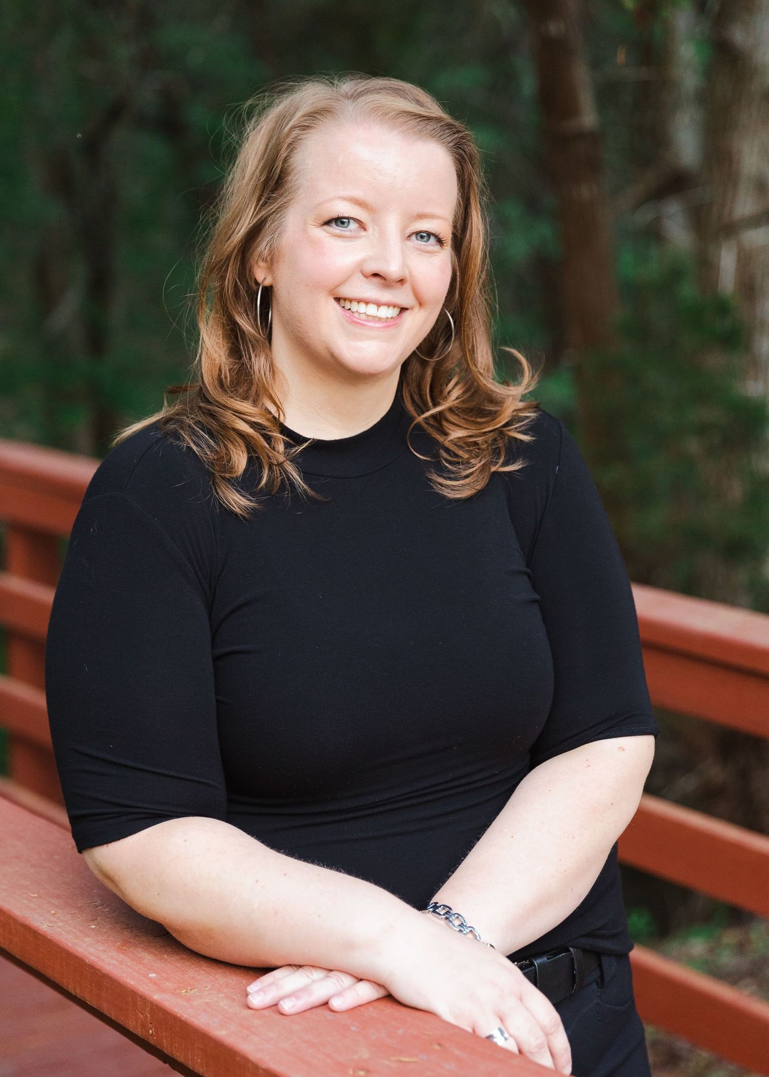Outdoor portrait series on a wooden bench wearing all black attire.