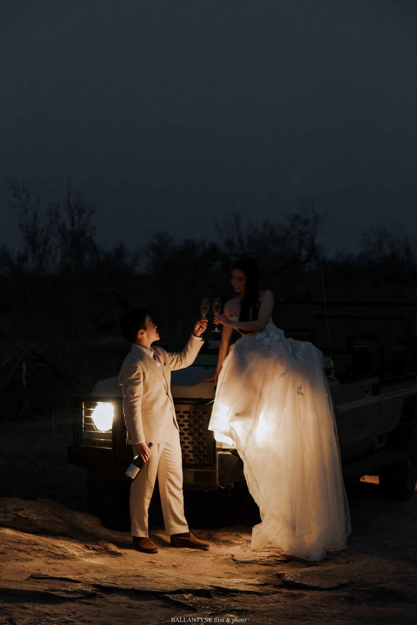 Dramatic nighttime wedding photo illuminated by flashlight.