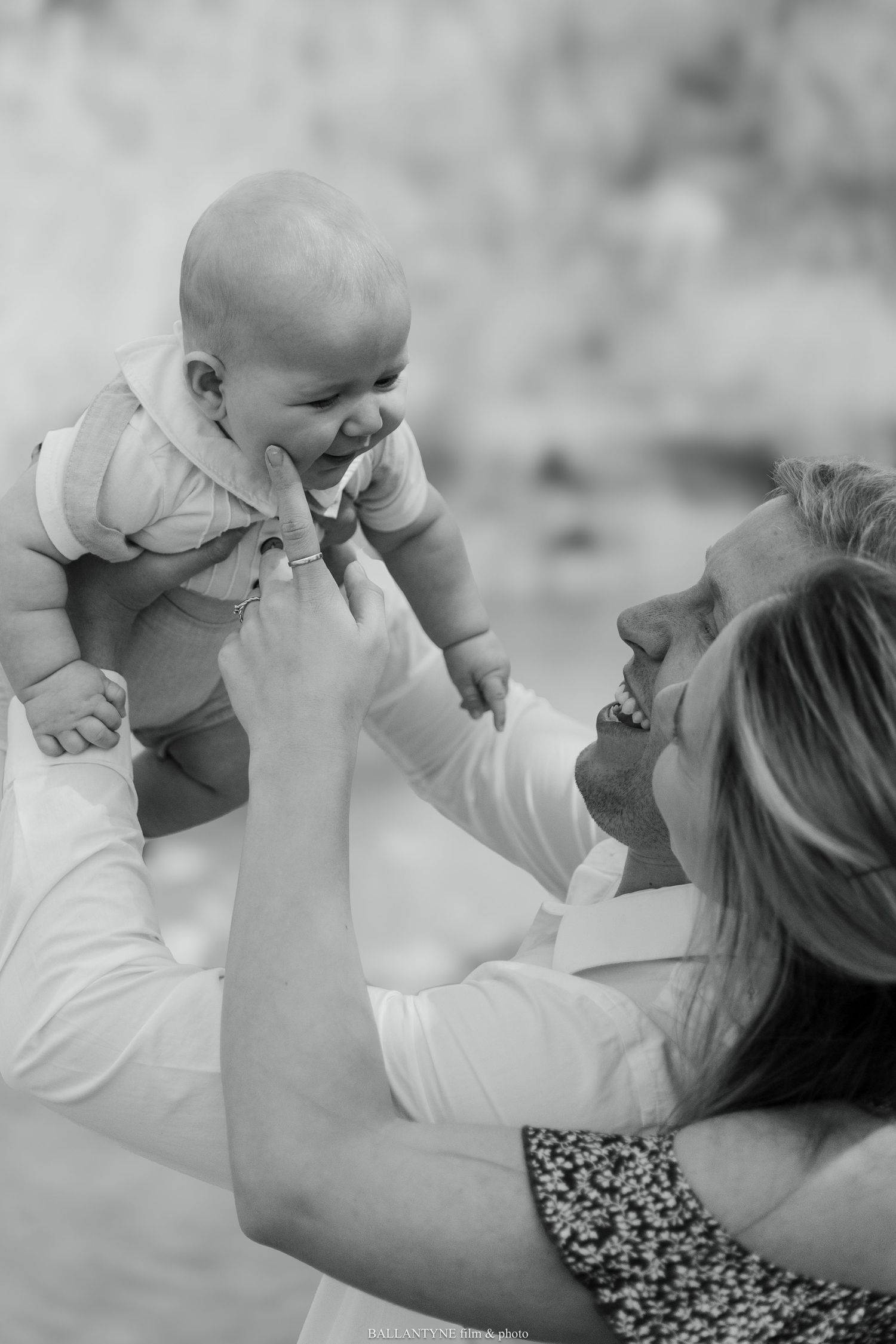 Tender moment between parent and baby in black and white photography.