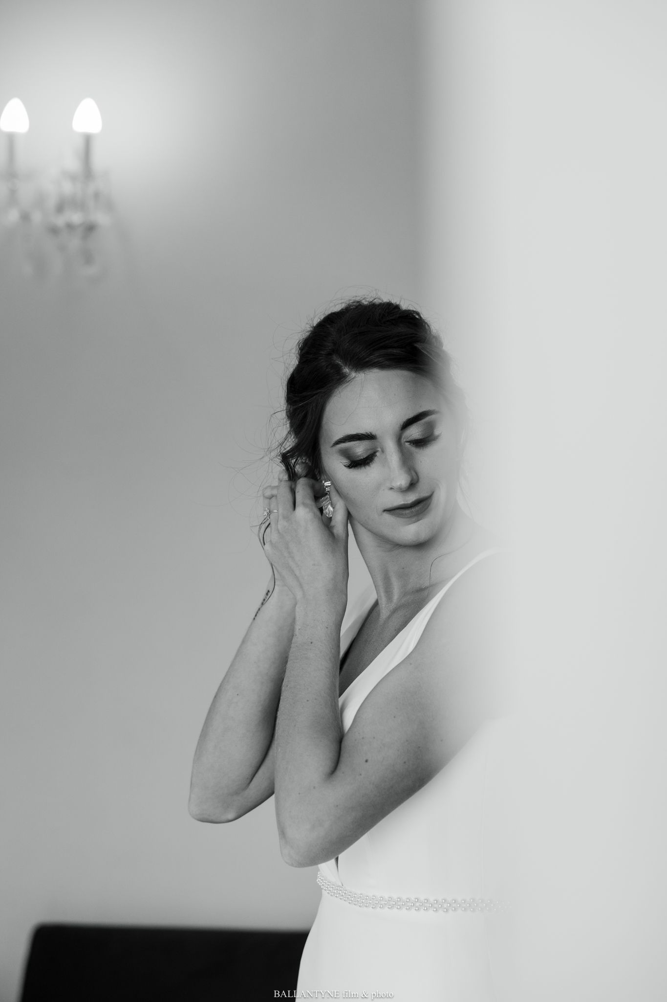 Elegant black and white portrait showing preparation moments in soft lighting.