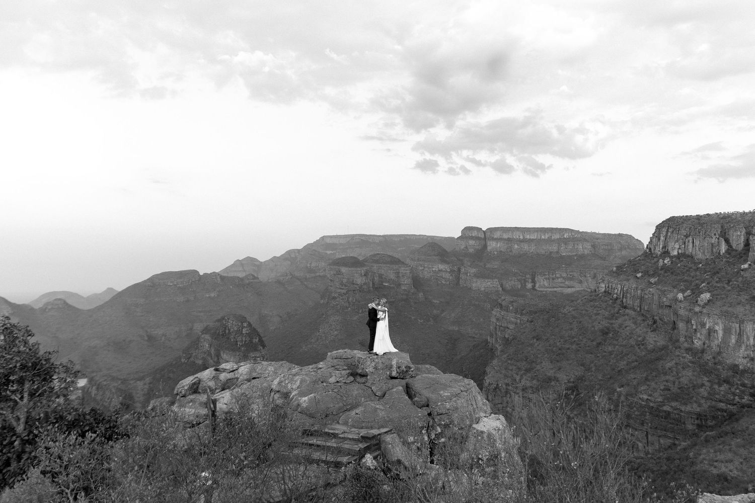 A panoramic black and white mountain landscape with rugged cliffs and valleys stretches across the horizon.